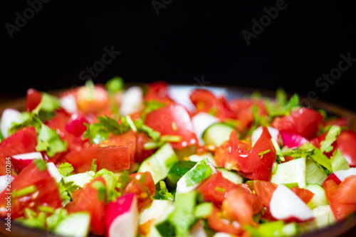 Close-up, delicious fresh vegetable salad cucumber tomatoes radishes cheese greens, vegetarian cuisine, healthy food, diet