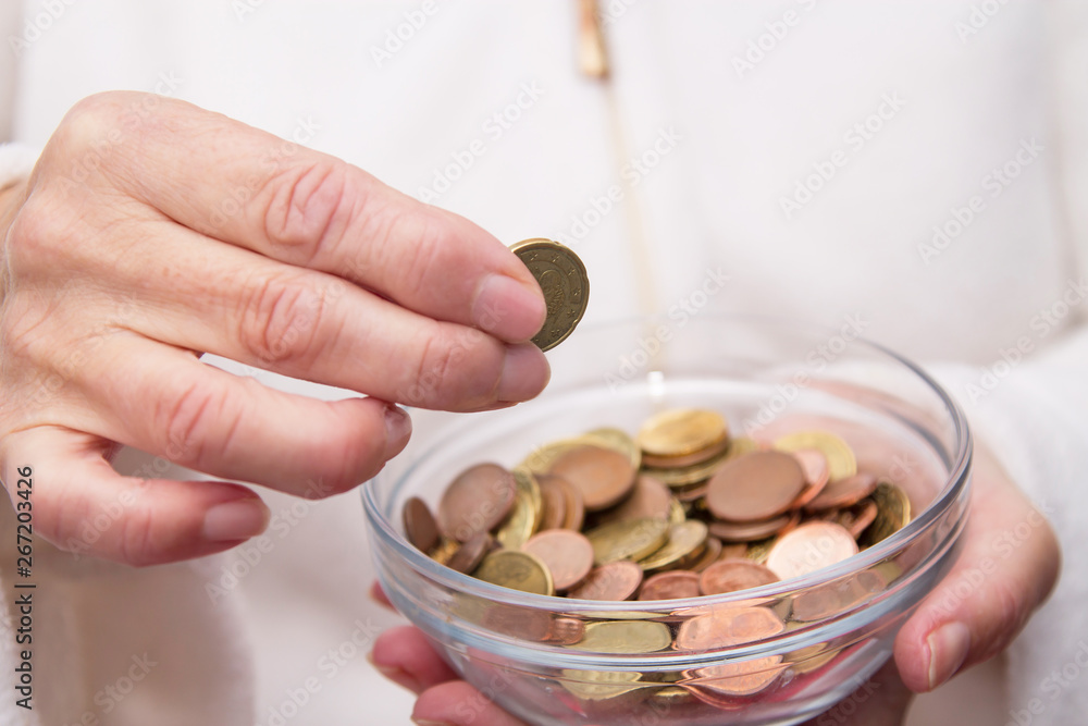 Fototapeta premium woman's hands holding jar of coins and entering a, savings concept