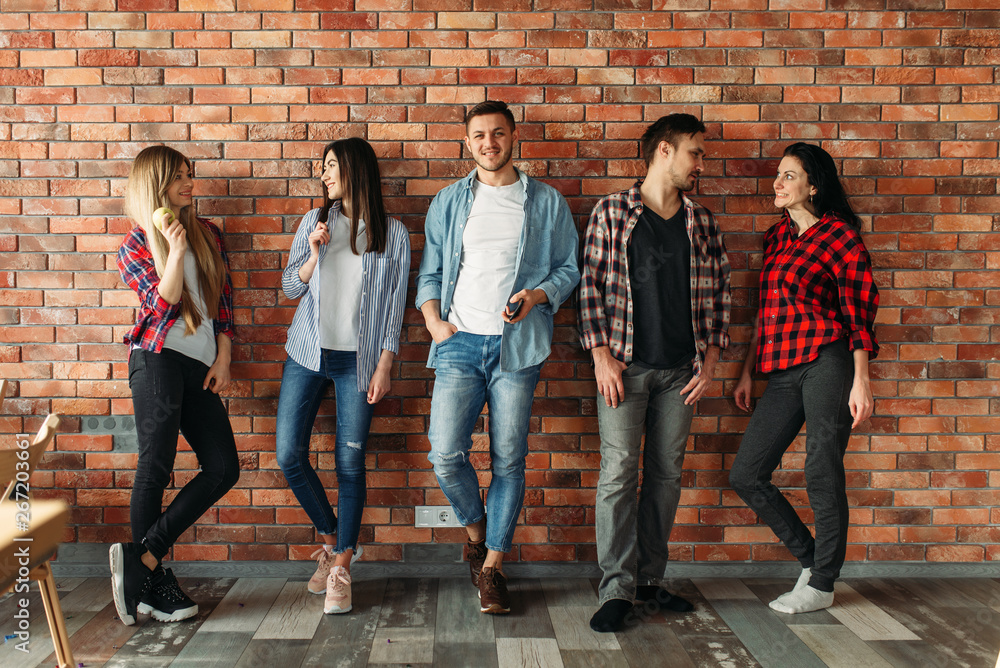 Fototapeta premium Group of students standing at the brick wall
