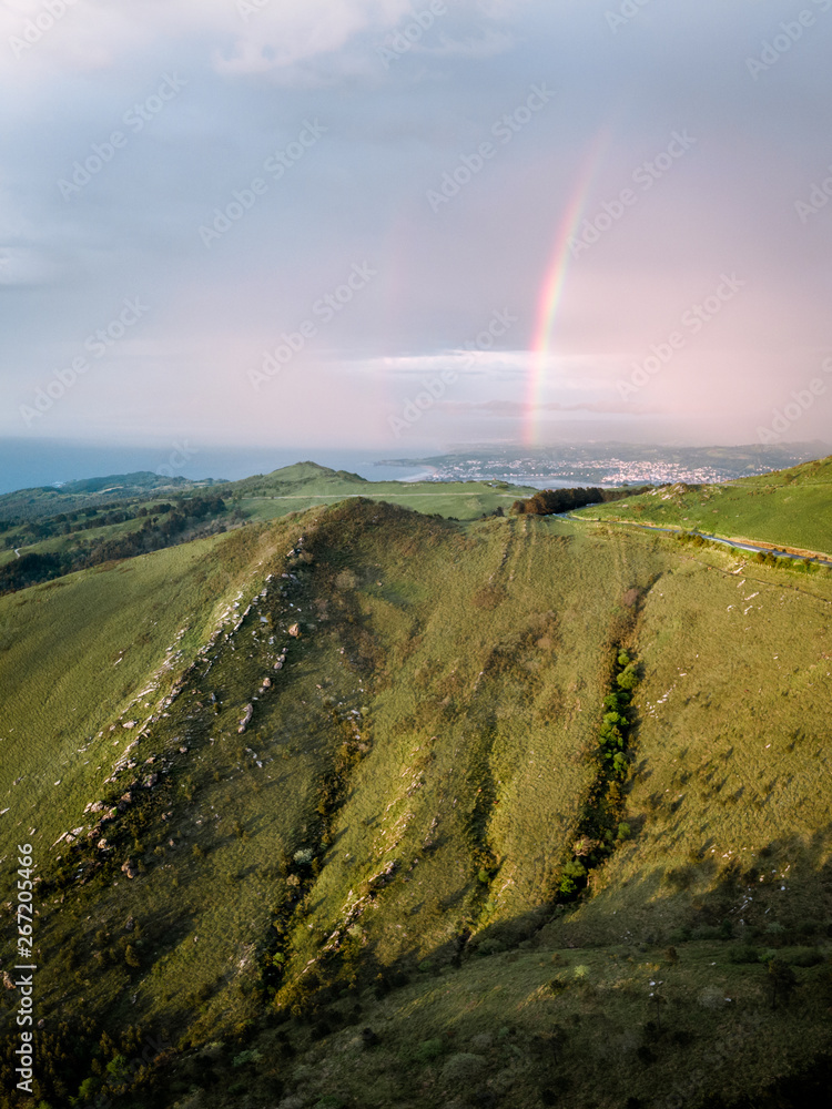 Green fields leading into a rainbow in the sky after de rain Green fields leading into a rainbow in the sky after de rain