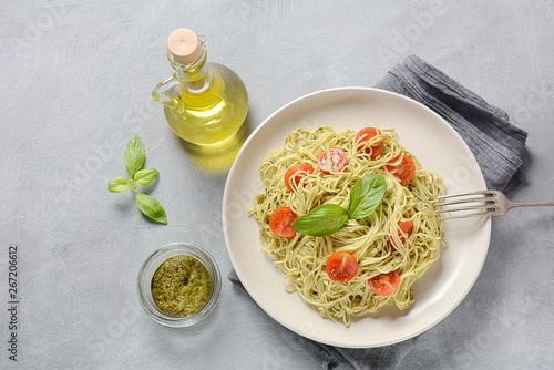 Pasta spaghetti with pesto sauce, fresh basil and cherry tomatoes . Italian traditional food