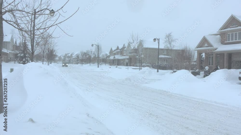 Snowstorm on a house lined street A snowed-in suburban street in a blizzard, with people clearing their driveways with shovels and snow blowers. The snowplows have not cleared the snow yet. Where are Snowstorm on a house lined street A snowed-in suburban street in a blizzard, with people clearing their driveways with shovels and snow blowers. The snowplows have not cleared the snow yet. Where are
