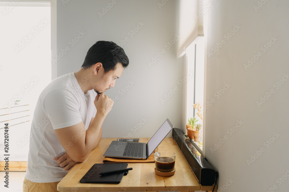 Asian freelancer man is thinking and working on his laptop. Concept of freelance creative works.
