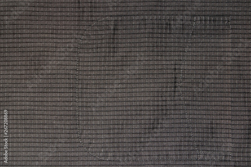 Background, texture of old cotton fabric in a cage with a sewn pocket.