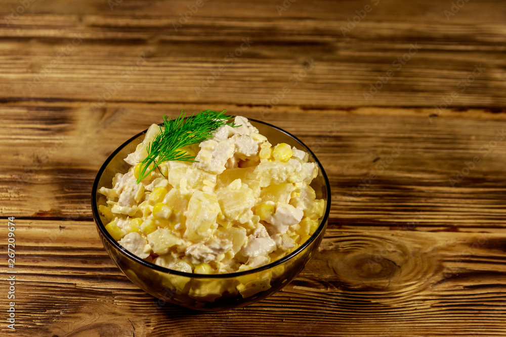 Festive salad with chicken breast, sweet corn, canned pineapple, cheese and mayonnaise on wooden table Festive salad with chicken breast, sweet corn, canned pineapple, cheese and mayonnaise on wooden table