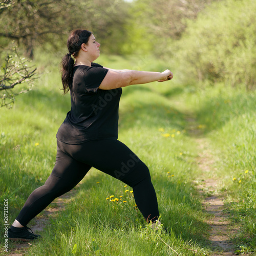 Overweight woman do morning training in the park. Healthy lifestyle, sport, weight losing, activity concept