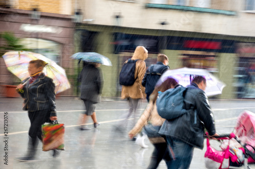 People with umbrella walking down the street on rainy day