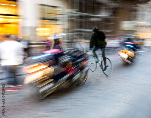 Dangerous city traffic situation with a motorcyclist and cyclist in motion blur
