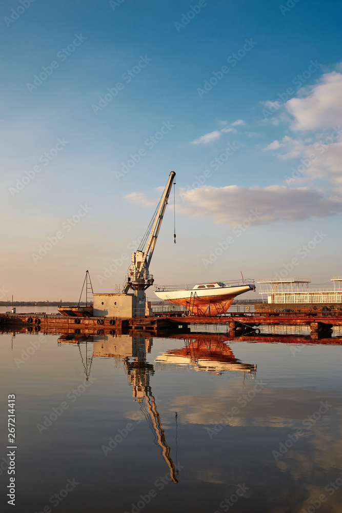 Fototapeta premium cranes in the evening port. sunny yacht club