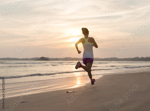 young fitness woman running at beach