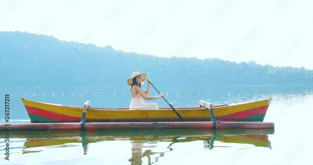 Beautiful girl kayaking on the catamaran at the ulun datu pura bratan temple, in Bali. Beautiful girl kayaking on the catamaran at the ulun datu pura bratan temple, in Bali.