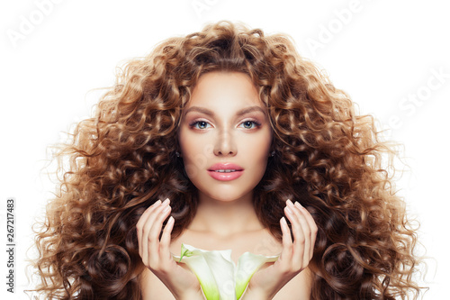 Beautiful young woman with long curly hair  clear skin and lily flower isolated on white