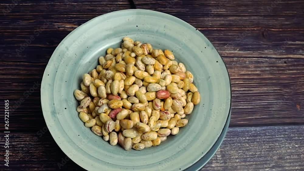 Raw white kidney beans in grey bowl rotating Raw white kidney beans in grey bowl rotating