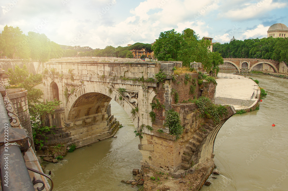 Ruins Bridge over the Tiber River in Rome, Italy. Old bridge passing through Rome, Italy