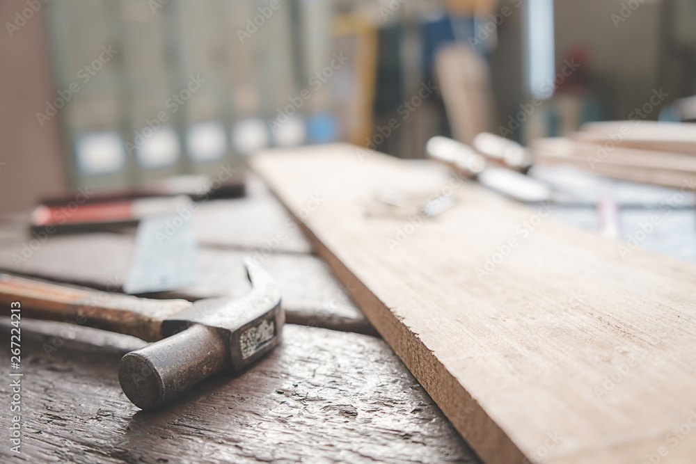 Equipment on wooden desk with man working in workshop background. Equipment on wooden desk with man working in workshop background.