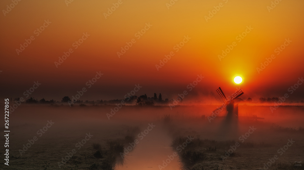 Windmühle im Nebel mit Sonnenlicht
