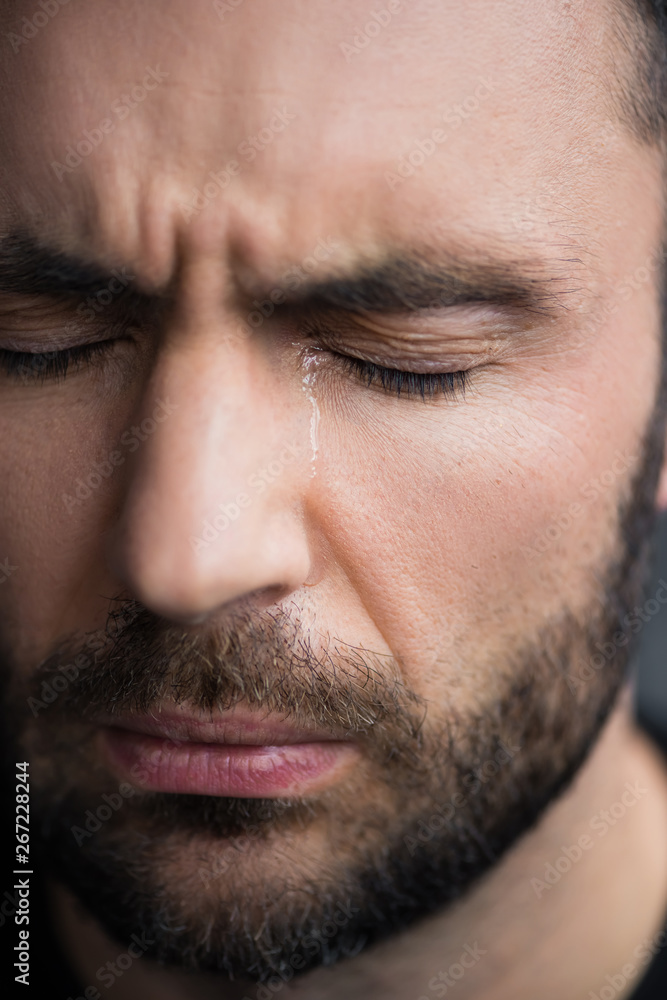Obraz premium portrait of handsome, bearded depressed man crying with closed eyes