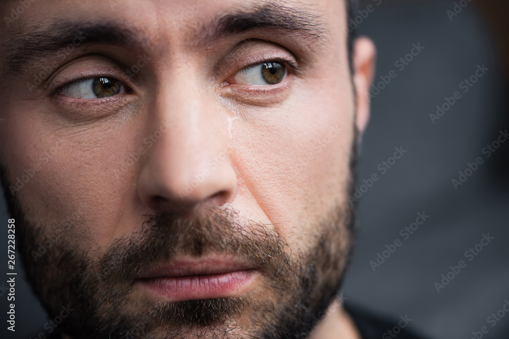 Obraz premium portrait of handsome bearded man crying and looking away