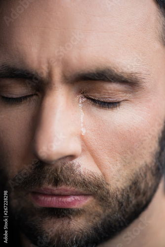 portrait of handsome depressed man crying with closed eyes