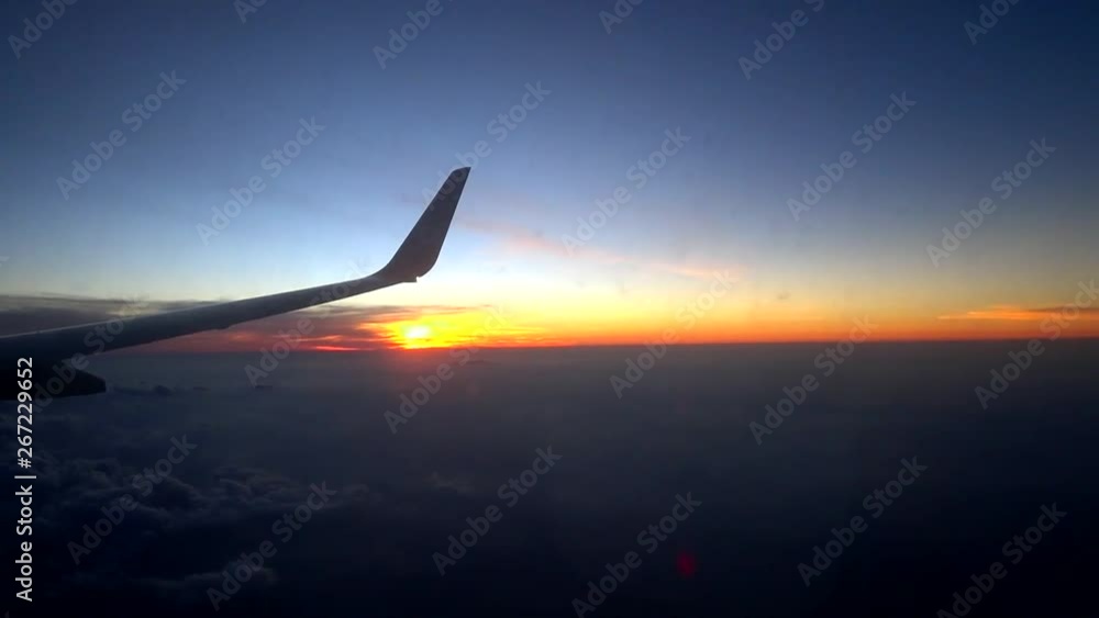 Airplane flying above the clouds overlooking the sun at the horizon. Airplane flying above the clouds overlooking the sun at the horizon.