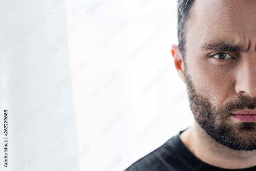 Fototapeta premium partial view of thoughtful, handsome bearded man looking at camera
