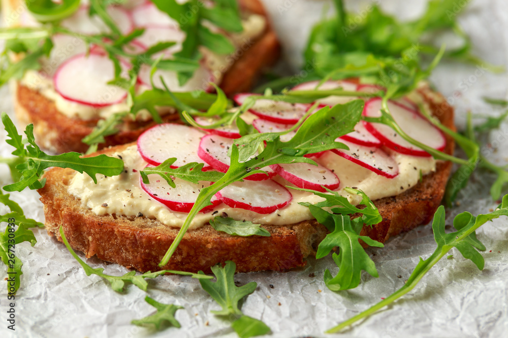 Hummus sourdough toast with reddish and wild rocket. Healthy vegan food Hummus sourdough toast with reddish and wild rocket. Healthy vegan food