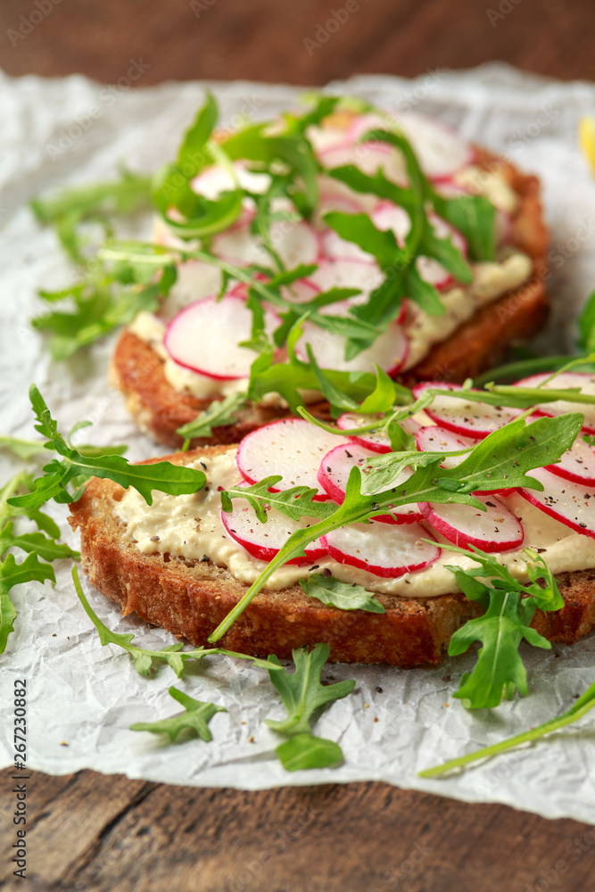 Hummus sourdough toast with reddish and wild rocket. Healthy vegan food Hummus sourdough toast with reddish and wild rocket. Healthy vegan food