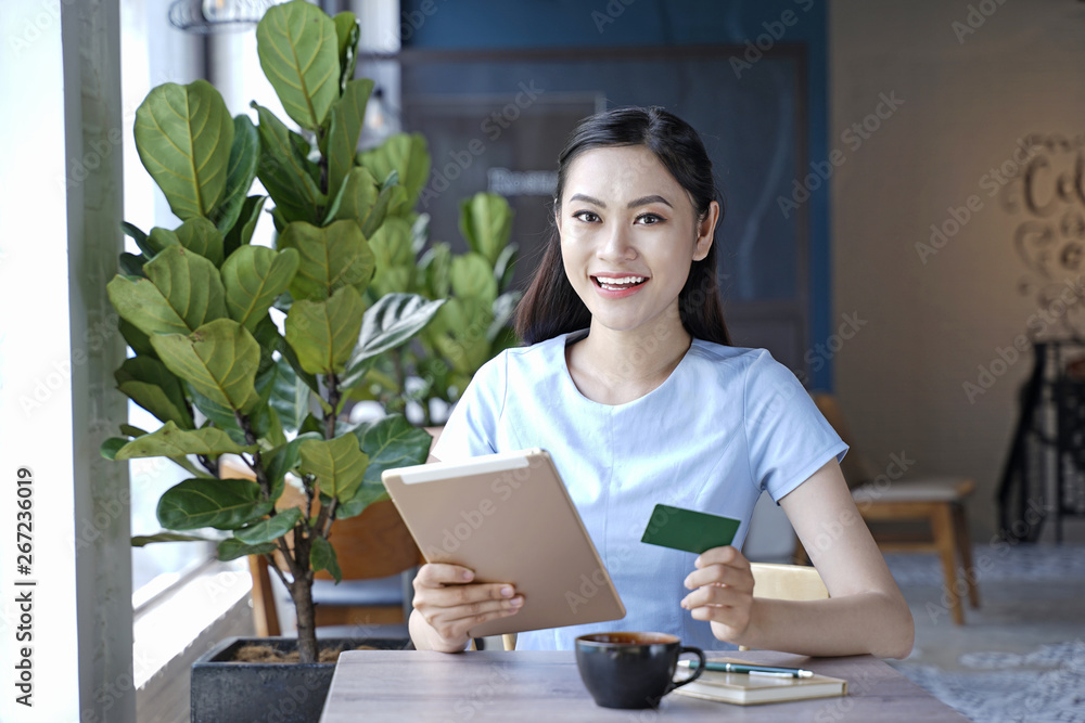 Asian pretty attractive woman sitting in coffee shop using smart phone Asian pretty attractive woman sitting in coffee shop using smart phone