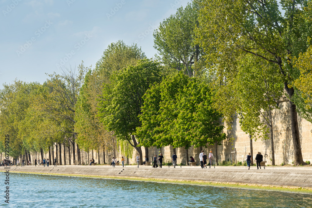 Frühlingsspaziergang in Paris - Seine-Ufer mit Menschen und grünen Bäume