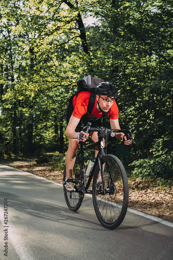 active cyclist in a red shirt goes fast on the highway