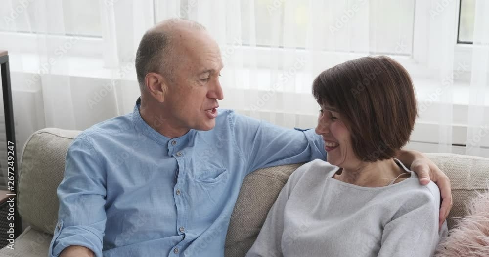 Senior couple having funny discussion on sofa Senior couple having funny discussion on sofa