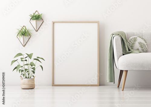 Fototapeta Naklejka Na Ścianę i Meble -  Poster mockup with vertical frame standing on floor in living room interior with gray sofa, round pillow, green plaid and plant in basket on empty white wall background. 3D rendering.