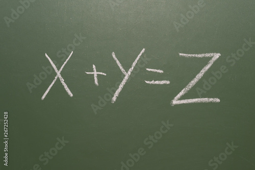 The inscription "x+y=z" in chalk on a blackboard
