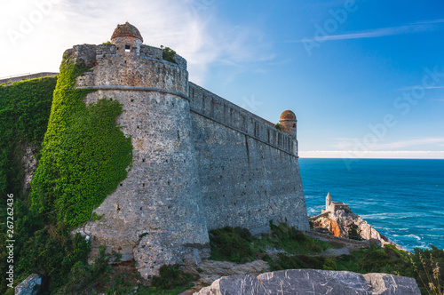 фотографія Andrea Doria Castle in Porto Venere, La Spezia, Italy, covered in green ivy, looking fairy tale like, overlooking the Gulf of Poets and the stunning Church of Saint Peter (Chiesa di San Pietro)