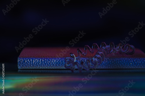 Dark colorful feminine composition of two notebooks and a transparent hair cable band