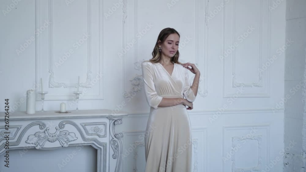 Gorgeous girl on the background of the fireplace, posing in an elegant beautiful dress. Slow motion Gorgeous girl on the background of the fireplace, posing in an elegant beautiful dress. Slow motion