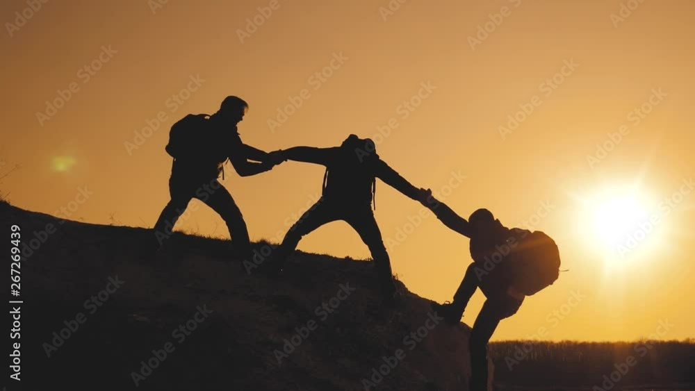 teamwork lifestyle help business travel silhouette concept. group of tourists lends a helping hand climb the cliffs mountains. people climbers climb to the top overcoming hardships the path to victory
