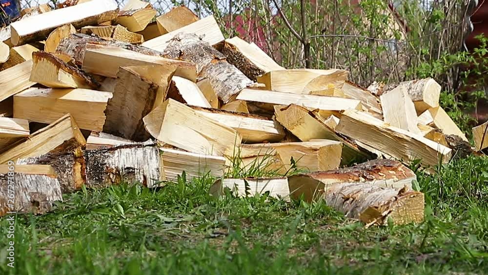 Firewood barbecue in the country house, a large pile of wood addition, summer day in the garden Firewood barbecue in the country house, a large pile of wood addition, summer day in the garden