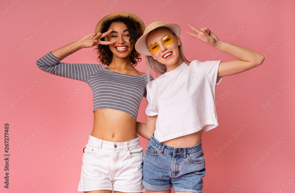 Carefree women fooling around together on pink background