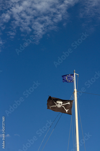 Pirate Flag and European flag in front of a blue sky