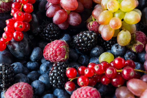 Background of fresh fruits and berries. Ripe blackberries  blueberries  plums and raspberries. Mix berries and fruits. Top view. Background berries and fruits. 