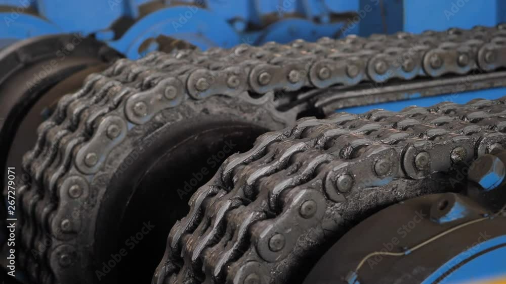 Chain gear. Machine with chain transmission at the factory. Close Up of machinery part. Industrial equipment. Metal chain and sprocket. Chain gear. Machine with chain transmission at the factory. Close Up of machinery part. Industrial equipment. Metal chain and sprocket.