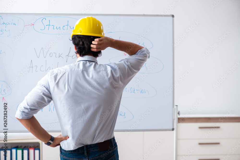 Young male architect in front of the whiteboard Young male architect in front of the whiteboard