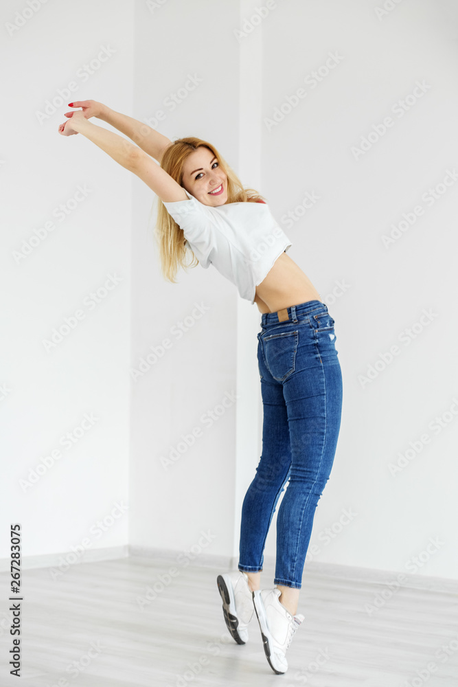 Slender girl dancing in jeans and sneakers. The concept of sport, dance and  lifestyle. Stock Photo | Adobe Stock