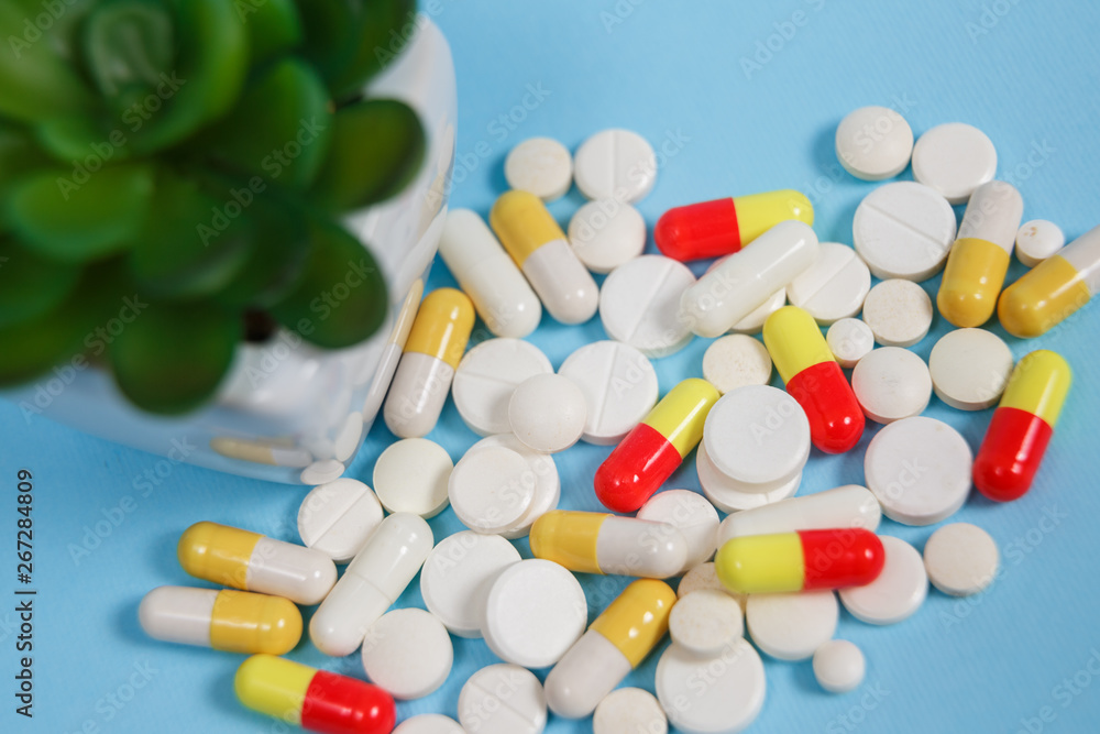 Pills are scattered over a blue background Pills are scattered over a blue background