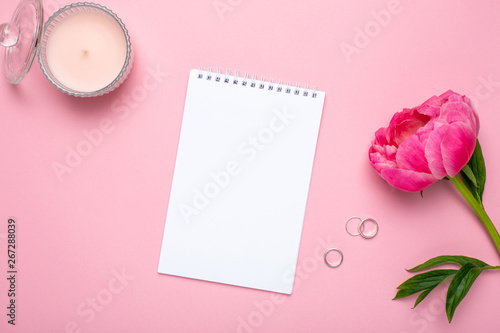 Beautiful pink peony flower and notebook with copy space for your text on pastel pink background © KatrinaEra
