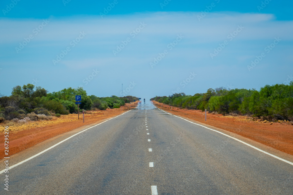 Mirage on endless straight road leading through Australian Bush