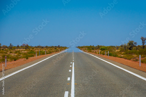 Mirage over straight endless road in Australia merging asphalt and sky