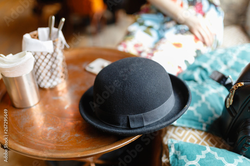 Black hat on a served wooden table in a cozy cafe.