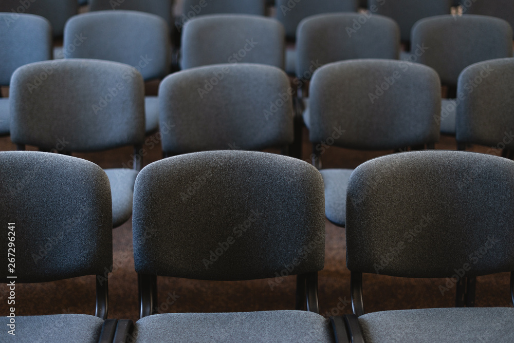 Photo of many chairs in handsome audience, at the some event Photo of many chairs in handsome audience, at the some event
